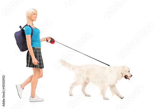Photo: Full length portrait of a female student walking a dog Full length portrait of a female student walking a dog