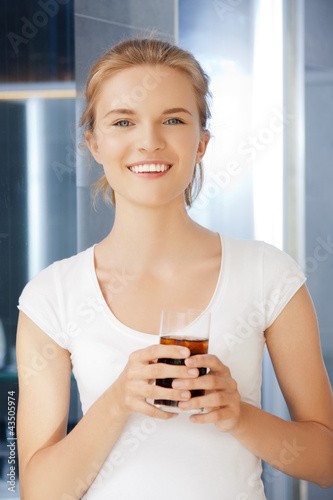 Foto: happy and smiling teenage girl with glass of cola happy and smiling teenage girl with glass of cola