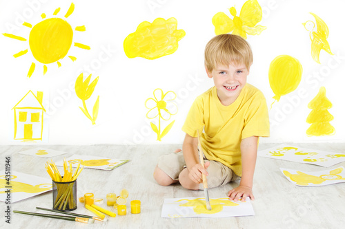 Photo: Happy child drawing with yellow color brush. Creativity concept. Happy child drawing with yellow color brush. Creativity concept.