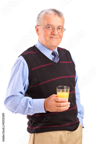 Photo: Mature man holding a glass of orange juice Mature man holding a glass of orange juice