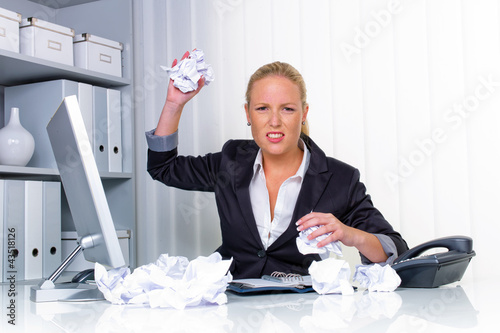Foto: Frau im Büro mit zerknülltem Papier Frau im Büro mit zerknülltem Papier