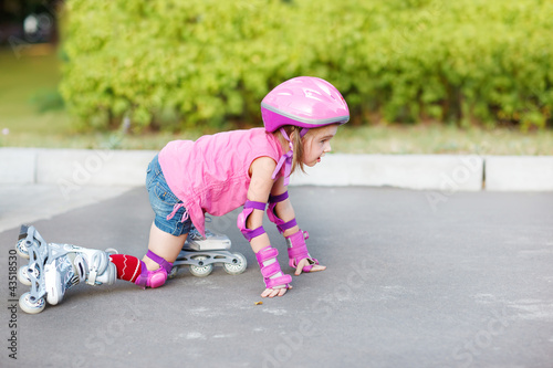 Girl in roller skates getting up