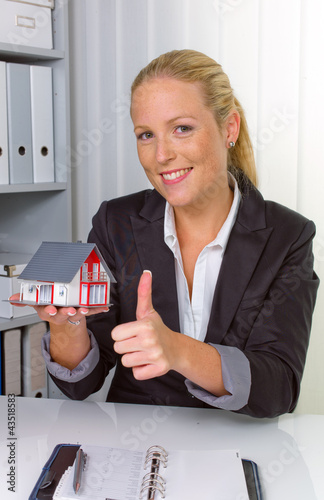 Photo: Immobilienmaklerin in ihrem Büro Immobilienmaklerin in ihrem Büro