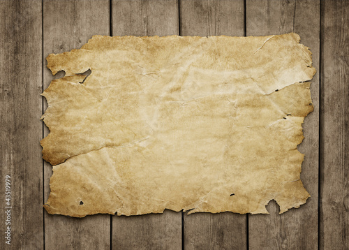 Photo: Old paper sheet at grunge wooden background Old paper sheet at grunge wooden background