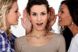 Women whispering to each other