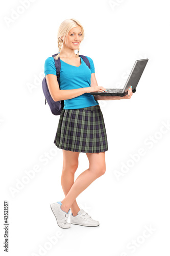 Photo: Full length portrait of a female student holding a laptop Full length portrait of a female student holding a laptop