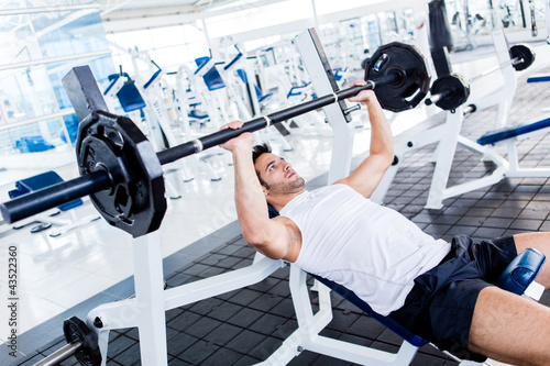 Foto: Gym man lifting weights Gym man lifting weights