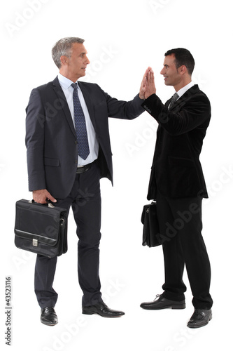 Foto: Two businessmen giving each other high-five Two businessmen giving each other high-five