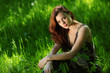 brunette sitting on green grass