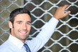 Smiling man standing in front of a shop grille