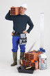 A bricklayer posing with his tools and building materials