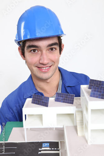 Photo: Tradesman posing with an eco-friendly building model Tradesman posing with an eco-friendly building model