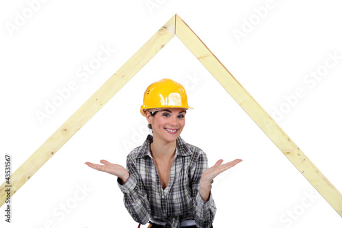 Photo: Female carpenter presenting wooden frame Female carpenter presenting wooden frame