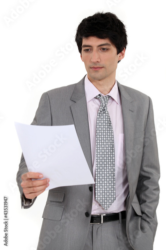 Foto: Man in suit reading document Man in suit reading document