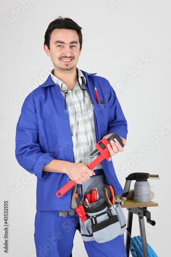 Foto: Man stood with wrench and blow torch Man stood with wrench and blow torch