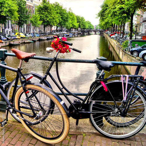 Photo: Bicycle along a canal in Amsterdam, the Netherlands Bicycle along a canal in Amsterdam, the Netherlands