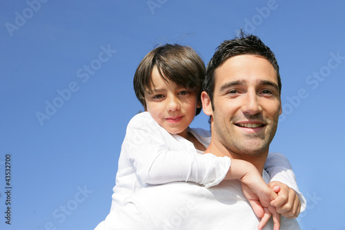 Photo: little boy on his father's back little boy on his father's back