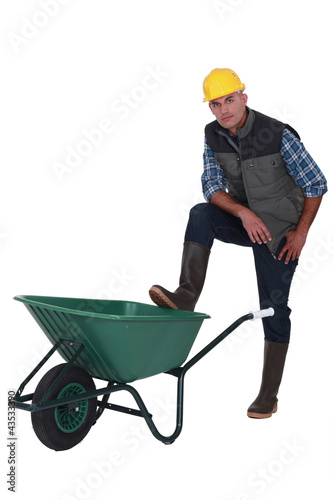 Photo: Man resting foot on wheelbarrow Man resting foot on wheelbarrow