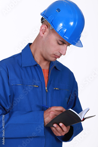 Foto: Tradesman writing in his agenda Tradesman writing in his agenda