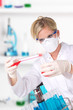 Foto: Young attractive laboratory assistant pouring chemical liquid Young attractive laboratory assistant pouring chemical liquid