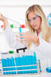 Foto: Young attractive laboratory assistant droping chemical liquid Young attractive laboratory assistant droping chemical liquid