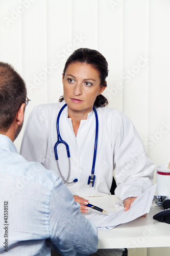 Photo: Arzt in Arztpraxis mit Patient. Gespräch Arzt in Arztpraxis mit Patient. Gespräch