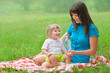 Photo: mother and daughter have picnic drinking clear water from bottle mother and daughter have picnic drinking clear water from bottle