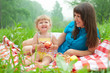 Photo: mother and daughter have picnic eating apples outdoor mother and daughter have picnic eating apples outdoor