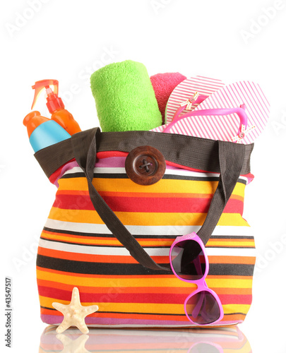 Photo: Beach bag with beach accessories, isolated on white Beach bag with beach accessories, isolated on white