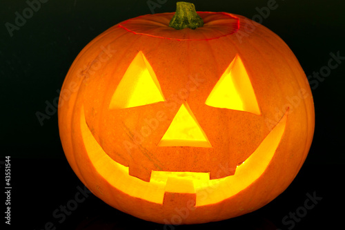 Photo: Halloween pumpkin with scary face over black Halloween pumpkin with scary face over black