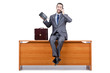 Businessman sitting on desk and speaking phone