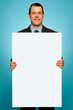 Corporate man holding big white blank billboard