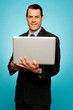 Attractive businessman holding laptop