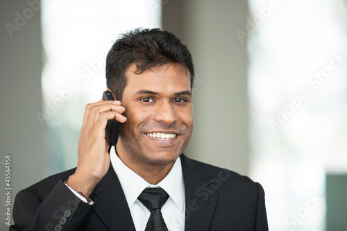 Photo: Indian business man using mobile phone. Indian business man using mobile phone.