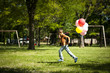 Little boy running with balloons