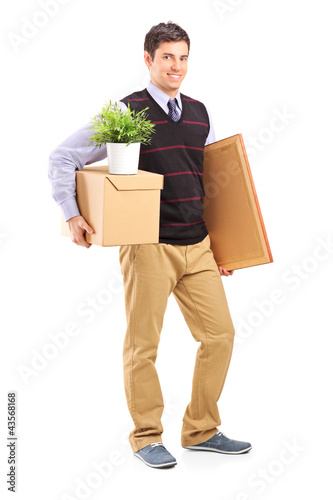 Foto: Full length portrait of a person with moving box and other stuff Full length portrait of a person with moving box and other stuff