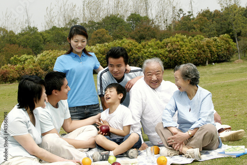 Photo: A big family picnicking in the park A big family picnicking in the park