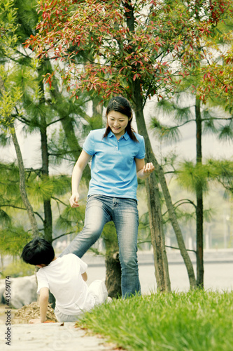 Photo: A woman kicking her brother A woman kicking her brother