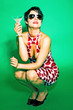 Woman in red and white polka dots dress squatting on the floor drinking cocktail 
