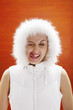 Woman in winter clothing licking her lip