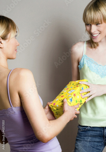 Photo: Woman receiving present from her friend Woman receiving present from her friend