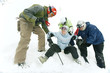 Male skiers helping female skier