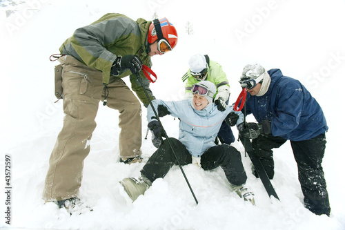 Photo: Male skiers helping female skier Male skiers helping female skier