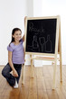 Photo : Girl holding a chalk with hand on the blackboard Girl holding a chalk with hand on the blackboard