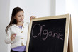 Photo : Girl looking at the word 'Organic' on the blackboard Girl looking at the word 'Organic' on the blackboard