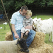 Man and boy sitting on haystacks