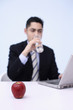 Businessman drinking water while using laptop