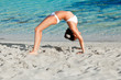 A woman is doing exercises on the beach