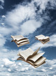 Photo: Three open books flying on blue sky Three open books flying on blue sky