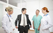 Businessman showing empty pockets to doctors